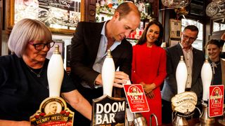 Prince William pulls a pint in a pub with Princess Catherine