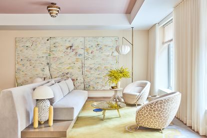 Manhattan interiors by Kelly Behun features a pastel palette and a carefully curated selection of design pieces and art. The living room features a rug and lighting by Behun, as well as a coffee table by Gaspare Asaro and a lamp (on the left) by Sunshine Thacker. On the wall is The Dance, a painting by Dashiell Manley 