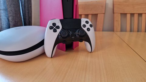 DualSense Edge review image showing the controller standing up against a pink PS5