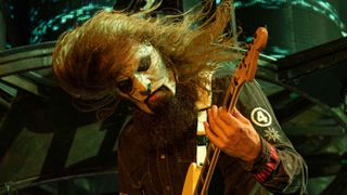 Slipknot’s Jim Root playing guitar and headbanging onstage