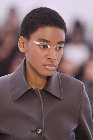 Model at Loewe wearing metallic accents, a key Spring/Summer 2025 fashion month beauty look