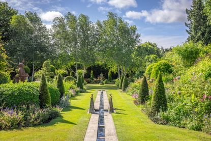 The West Garden at Alan Titchmarsh&rsquo;s Hampshire home, showing the rill, topiary and, on the left, a towering terracotta Humphry Repton made by Jim Keeling of Whichford Pottery in Warwickshire. Photo: Jonathan Buckley