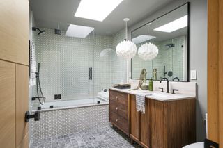 A modern bathroom with a double vanity and large shower