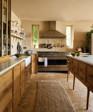 yellow ocher kitchen with painted walls and ceiling, tiled floor, rug, wooden cabinets, white countertop, open shelving, tiled backsplash, large oven, glazed counter units