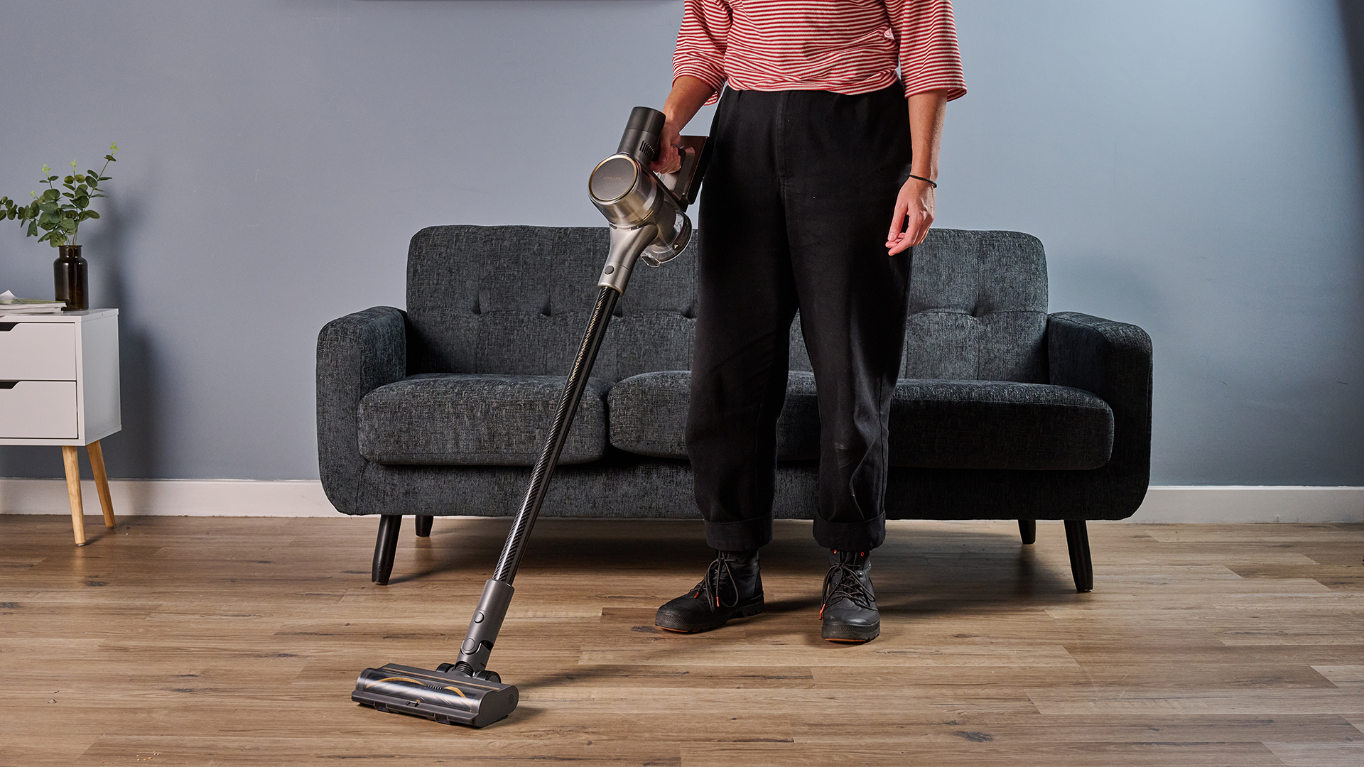 Ruth Hamilton holding Dreame R20 cordless stick vacuum, with a sofa and side table in the background