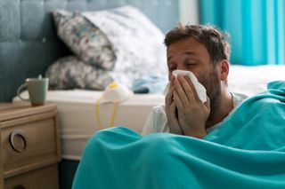 A man sneezing which is an Omicron symptom