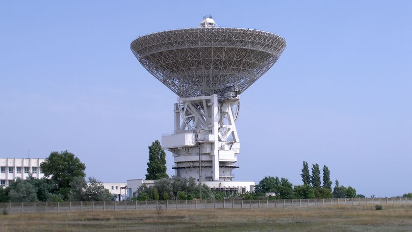 A large radio telescope with a giant antenna dish points to the sky