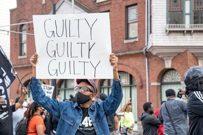 A person holds a sign celebrating Derek Chauvin's guilty verdict.