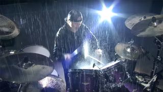 Metallica's Lars Ulrich plays in the pouring rain in Manchester