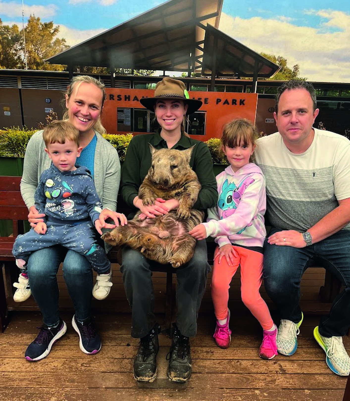 Amy and her family smiling with a koala and its keeper