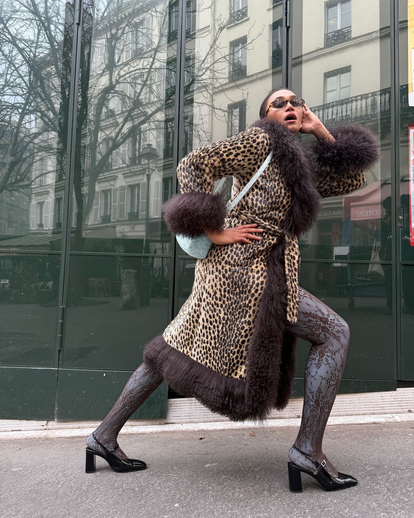 Léna Farouil wearing an animal-print coat with a furry trim with burgundy lace tights and black Mary Jane heels.