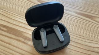 The Earfun Air Pro 3 true wireless earbuds in their charging case on a wooden surface