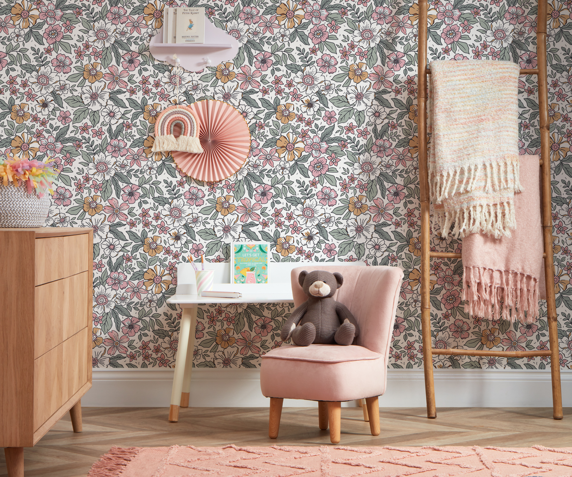 pink floral bedroom in child's bedroom with wooden furniture and small pink chair