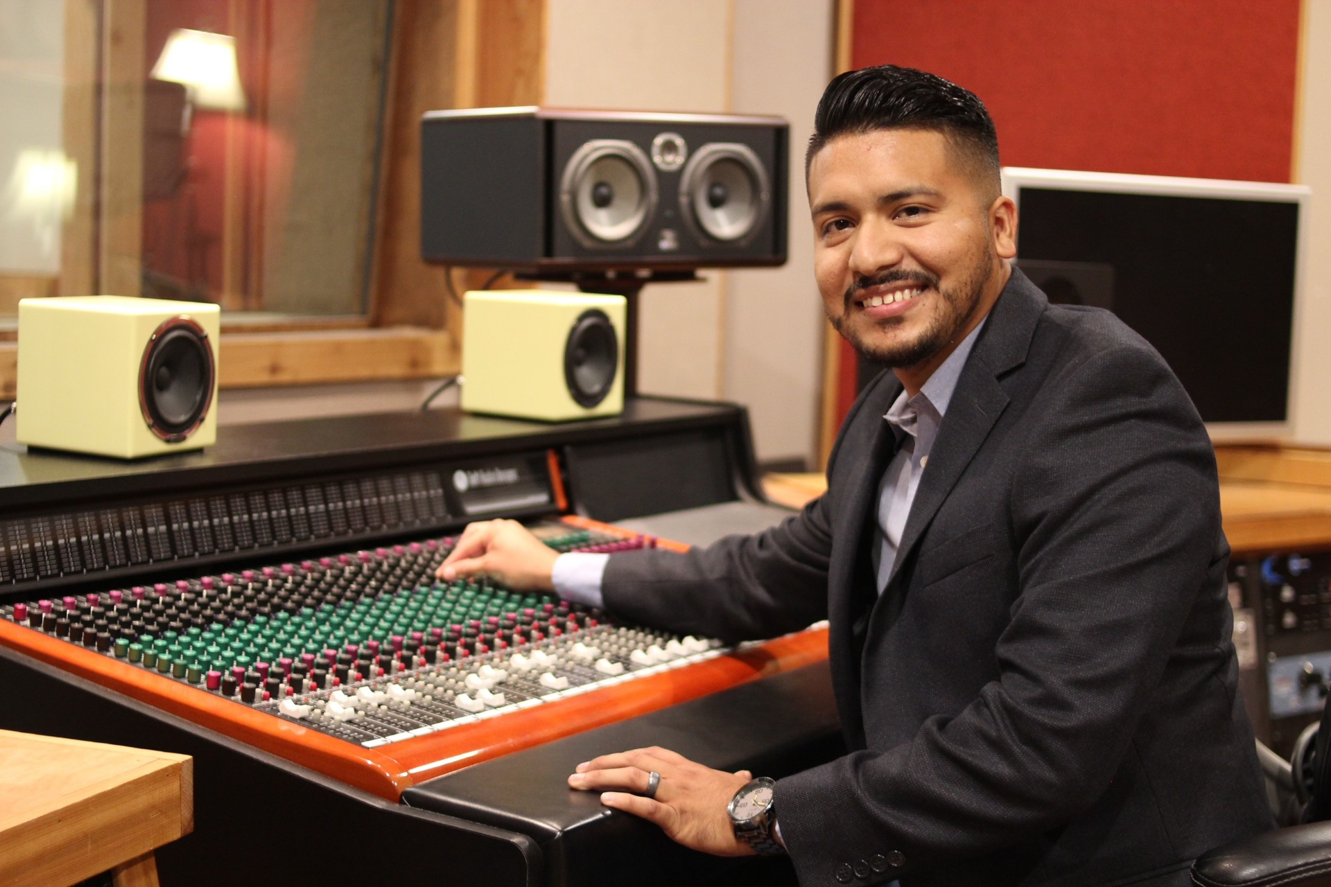 Smiling Hector Varela at a mixing console.