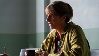 Susan sitting in the police station answering questions in a green jacket