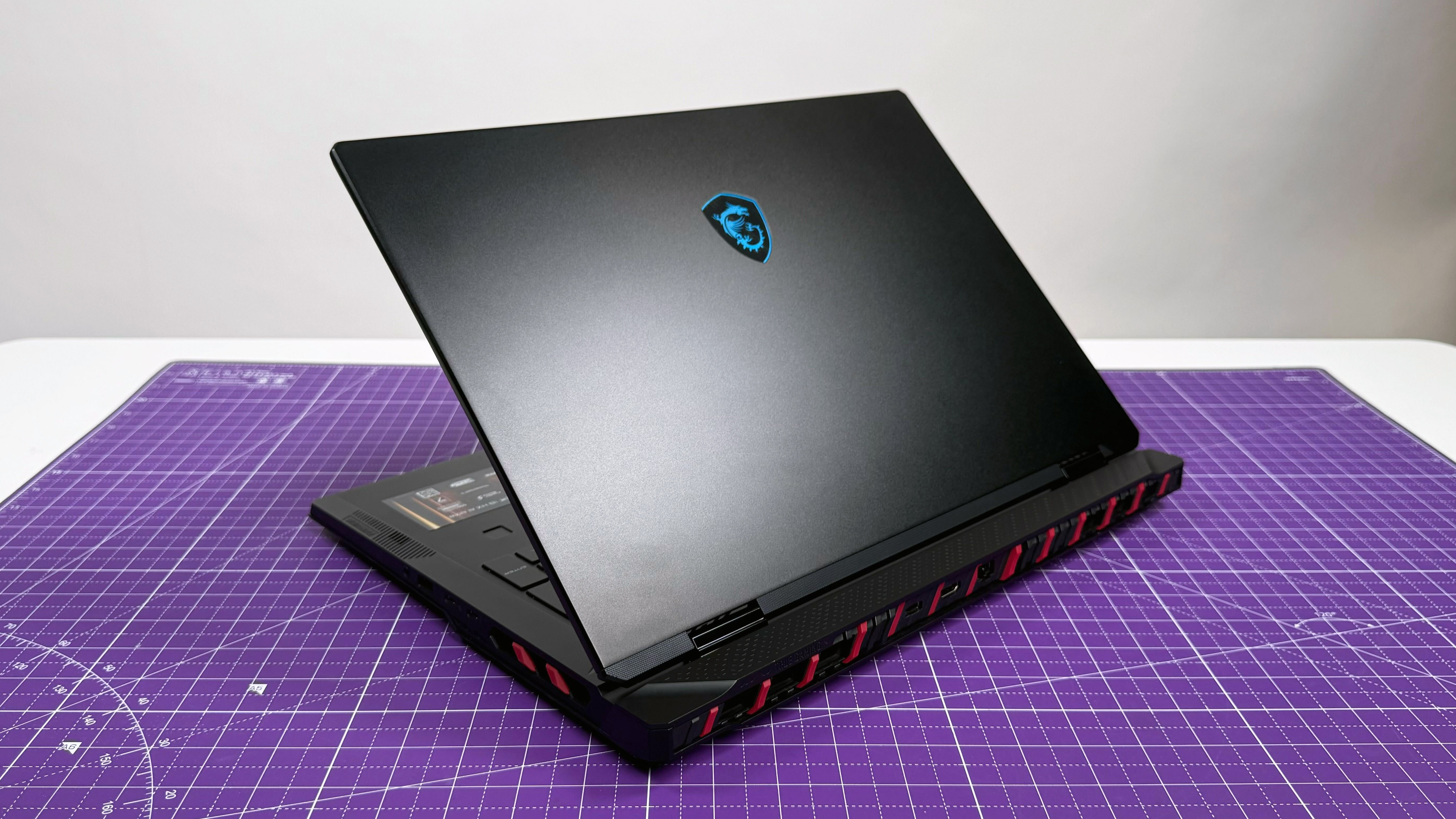 MSI Raider 18 HX AI gaming laptop facing away, on a purple mat against a gray background.