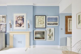 Light blue bedroom with gallery wall and fireplace