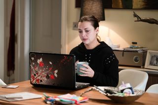 Whitney Dean worries about her baby as she looks at her laptop while drinking tea