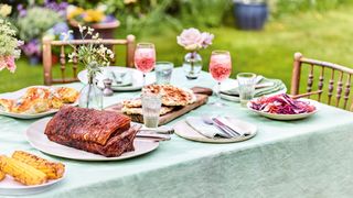outdoor dining table with green table cloth with bbq food and drinks: showing how to bbq right
