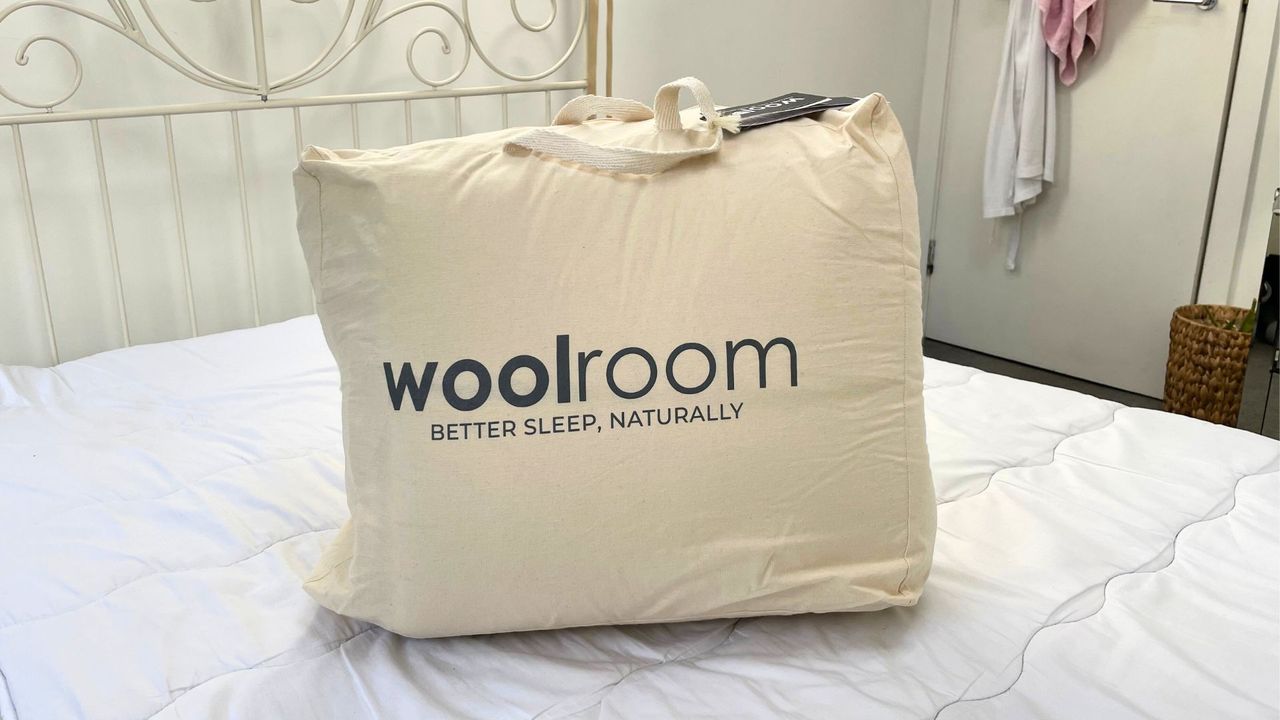 packaged woolroom mattress topper on top of bed