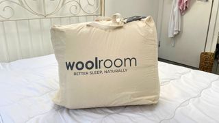 packaged woolroom mattress topper on top of bed