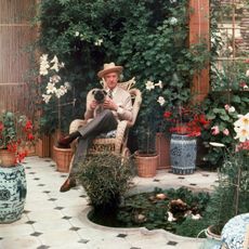 Cecil Beaton sitting with his pet pug