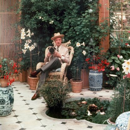 Cecil Beaton sitting with his pet pug