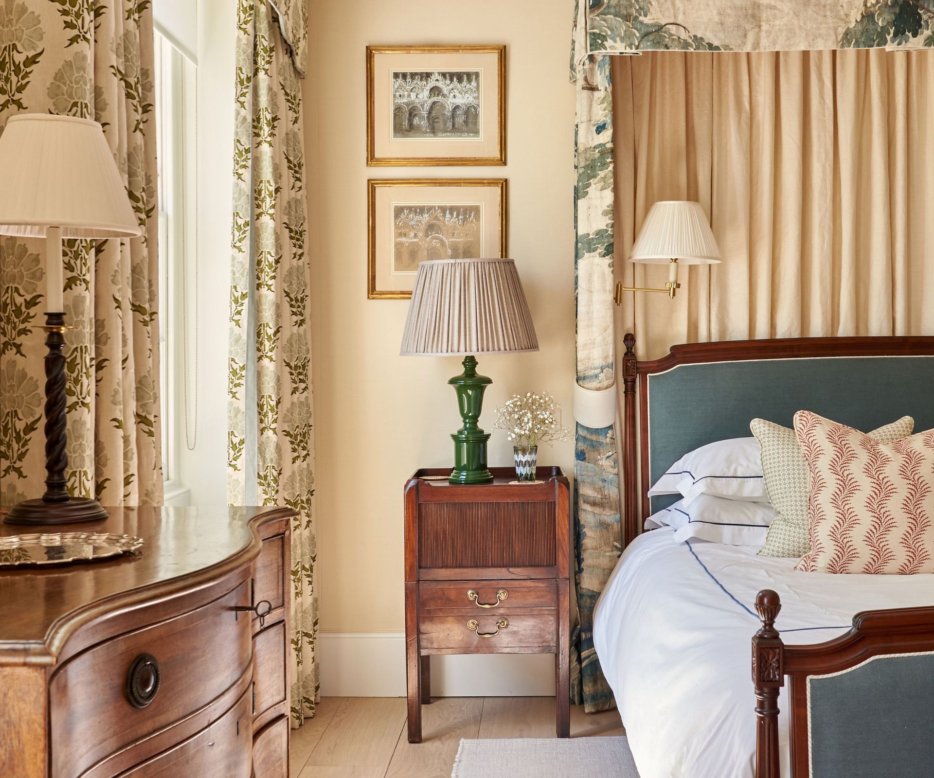 Vintage bedroom with printed drapes, wooden side table, vintage lamps and wooden bed