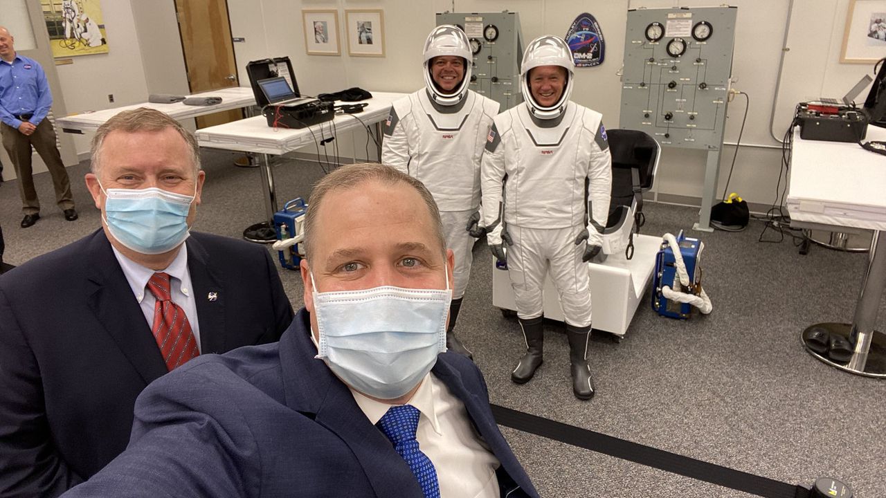 NASA Administrator Jim Bridenstine (bottom center) and Deputy Administrator Jim Morhard pose for a photo with Demo-2 astronauts Bob Behnken (background left) and Doug Hurley in their SpaceX spacesuits for a launch on May 30, 2020.