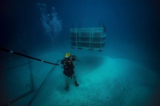 James Ward, a diver first class with the U.S. Navy, guides a salvage basket during an underwater recovery operation off the coast of Koror, Palau, on Jan. 30.