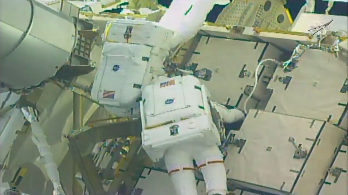 NASA astronauts Anne McClain (right) and Nick Hague work to connect cables between an adapter plate and a new lithium-ion battery.