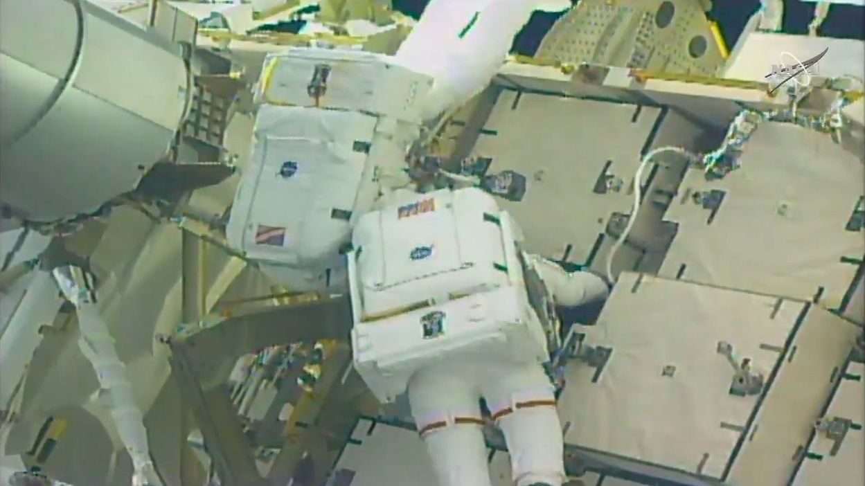 NASA astronauts Anne McClain (right) and Nick Hague work to connect cables between an adapter plate and a new lithium-ion battery.