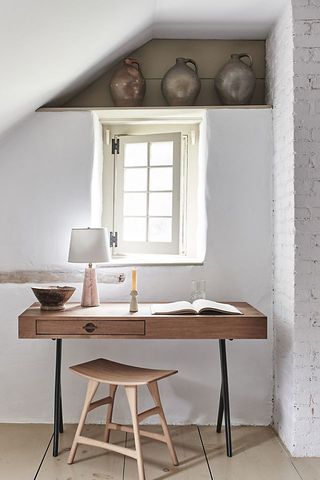 Anthropologie Palmer Desk in white room with wooden stool and large ceramics