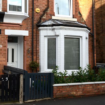 house with exposed brick walls white door and windows