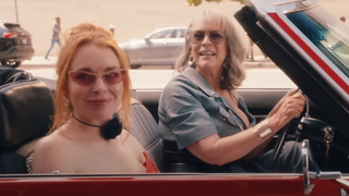 Lindsay Lohan and Jamie Lee Curtis in a convertible and sunglasses on looking over the passenger side in Freakier Friday