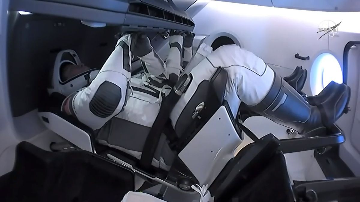 NASA astronauts Bob Behnken (foreground) and Doug Hurley sit inside their SpaceX Crew Dragon Demo-2 spacecraft before undocking from the International Space Station, on Aug. 1, 2020.