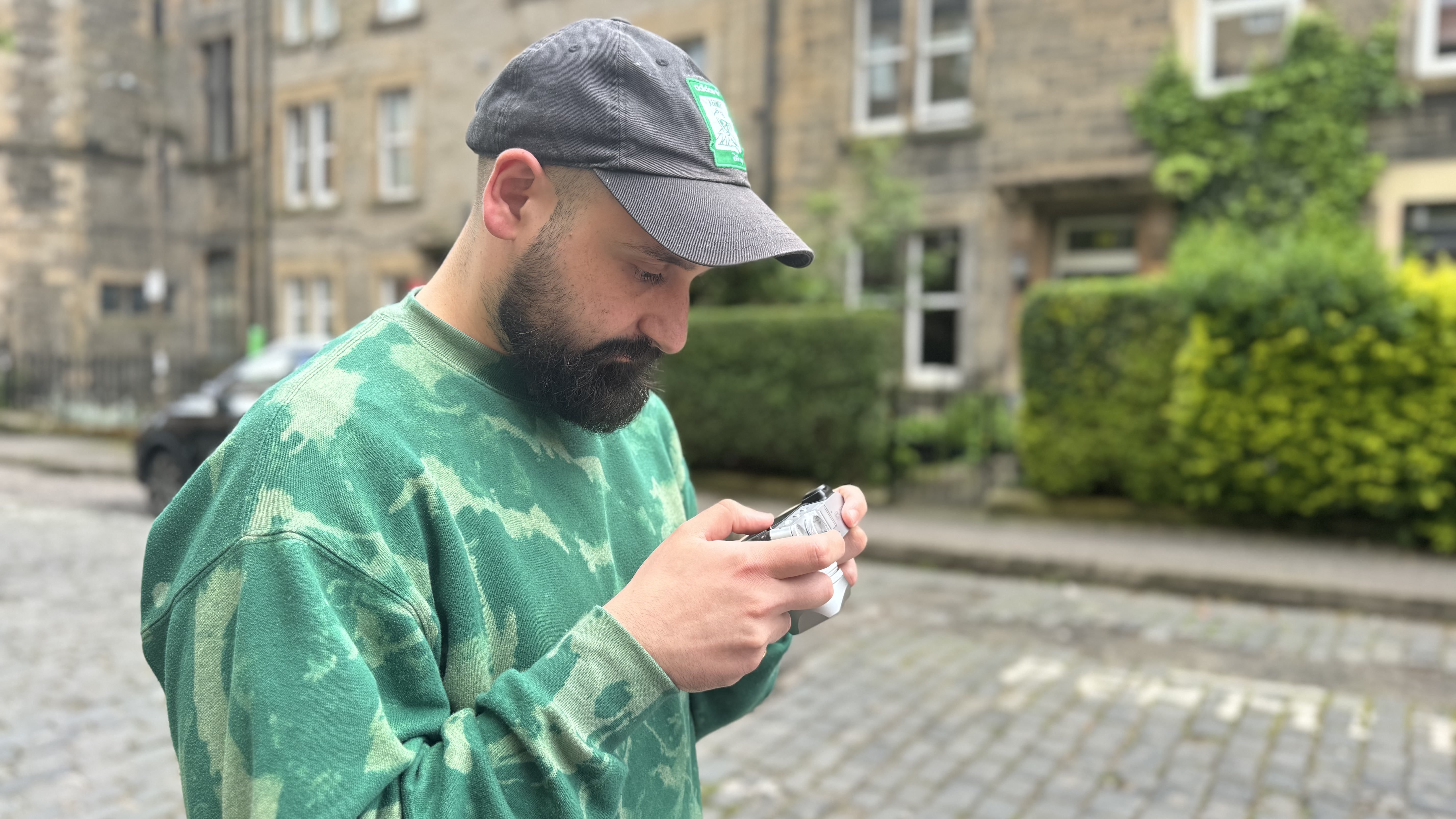 Un homme en pull vert prenant des photos avec le Fujifilm X100VI