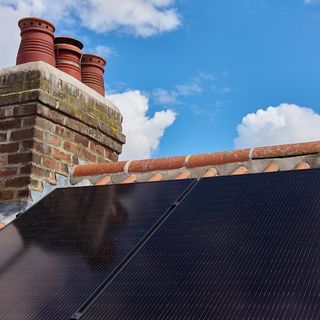 Fitted solar panels on roof with chimney