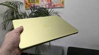 MacBook Neo laptop on a desk with plant in background
