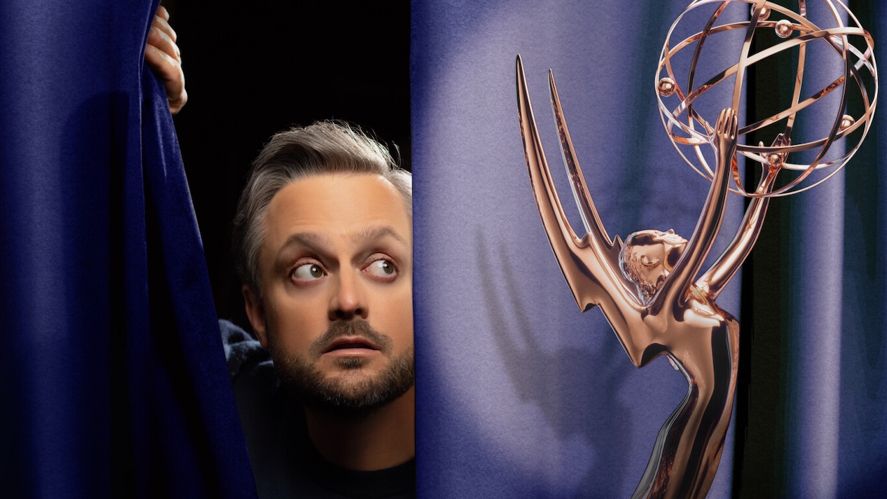 Nate Bargatze staring at Emmy trophy from behind curtain in key art for 2025 Emmys