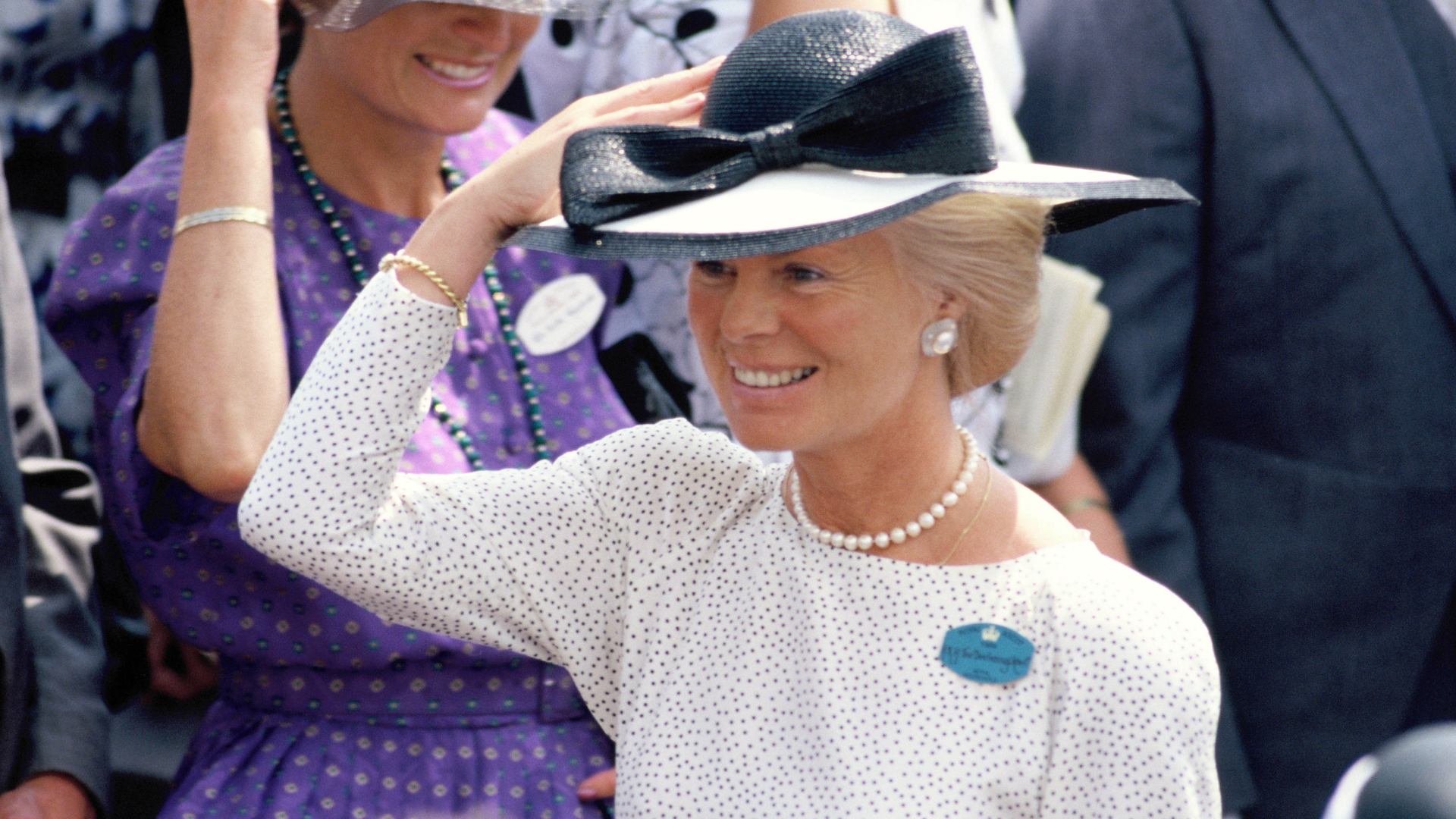 The Duchess of Kent wearing a white dress and black hat smiling
