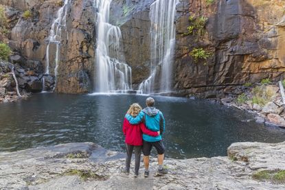 Australia, Victoria, Halls Gap, Tourist couple admiring MacKenzie Falls in Grampians National Park.