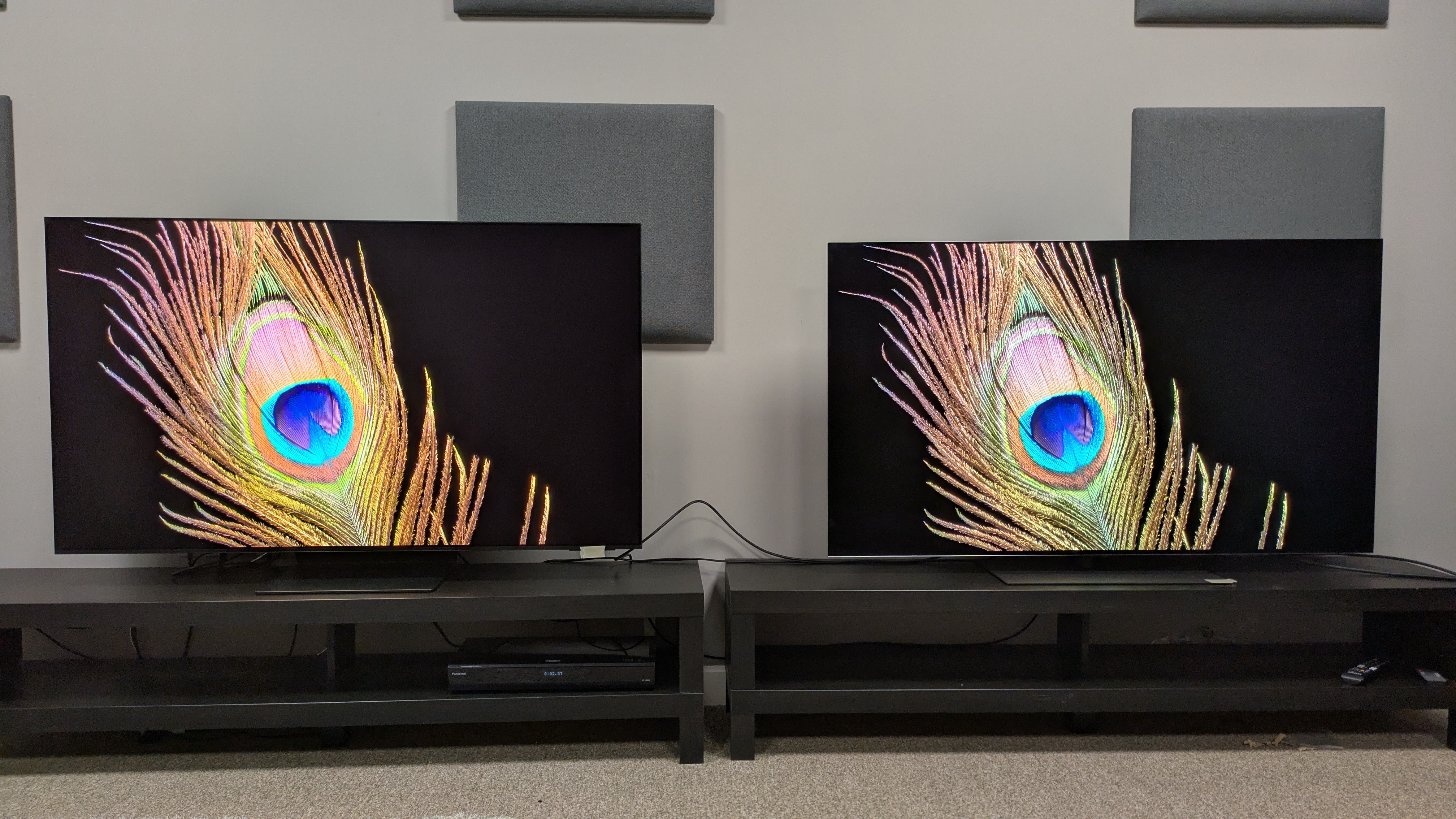 Samsung S95F vs LG G5 with peacock feather on screen