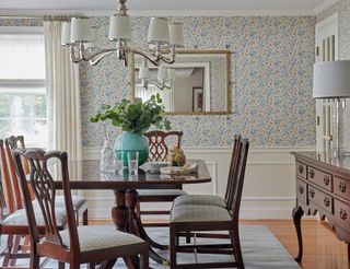 dining room with patterned wallpaper and wooden furniture