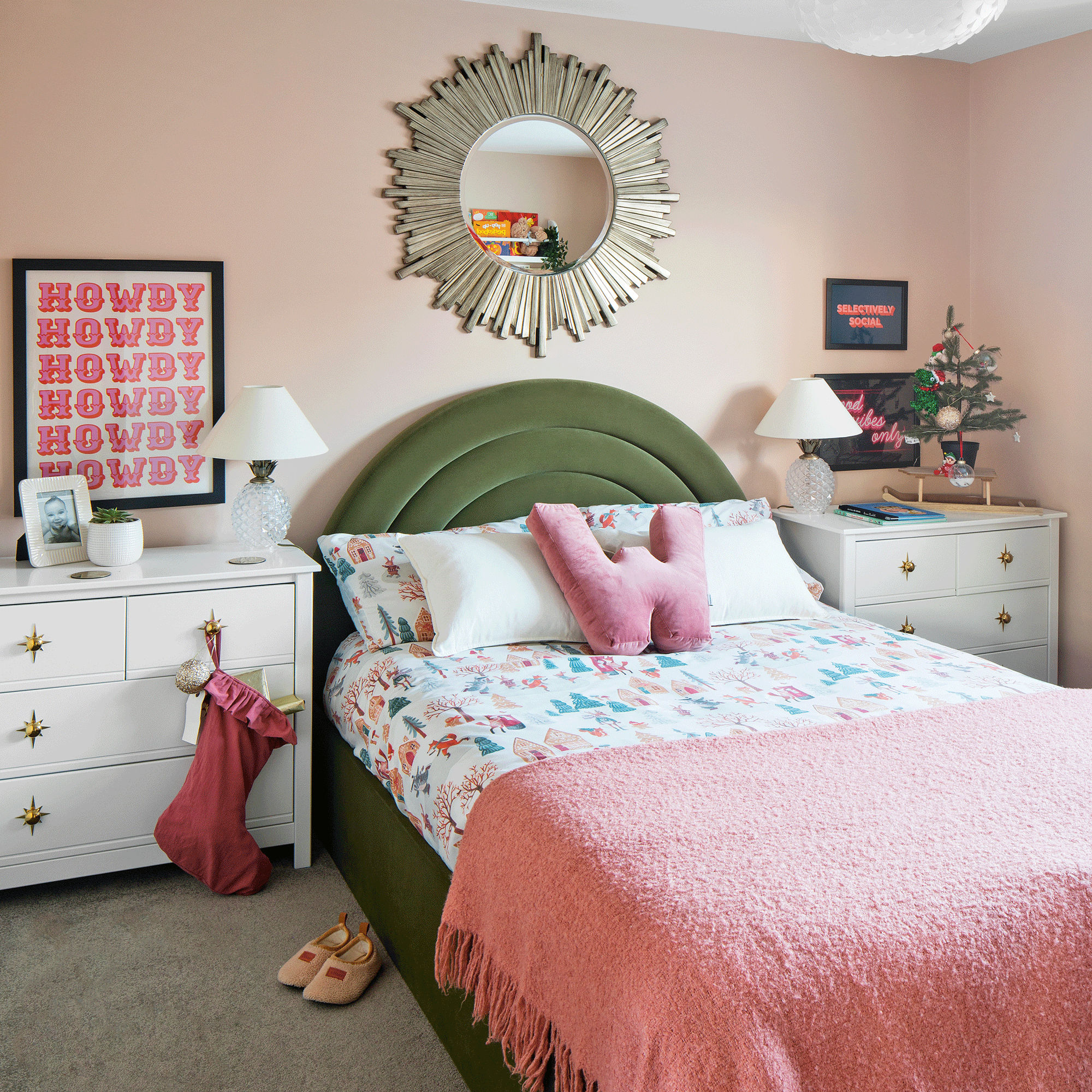 a child's bedroom with a green velvet headboard, lots of wall art and pink decorative accents