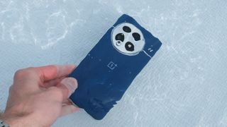 OnePlus 13 phone being dunked into a swimming pool