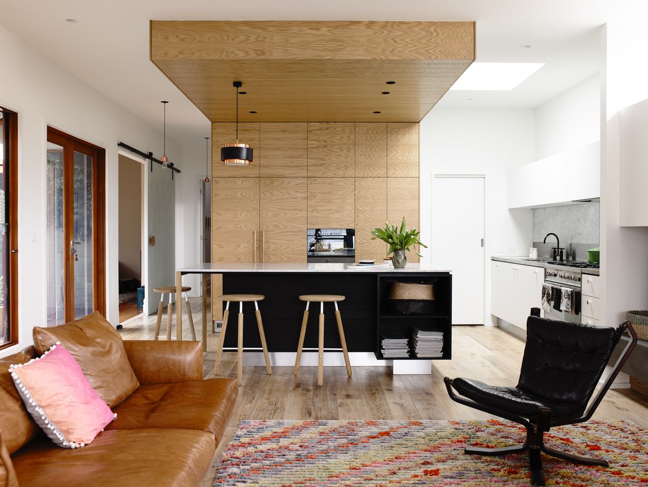 An open kitchen with a leather sofa placed close to it