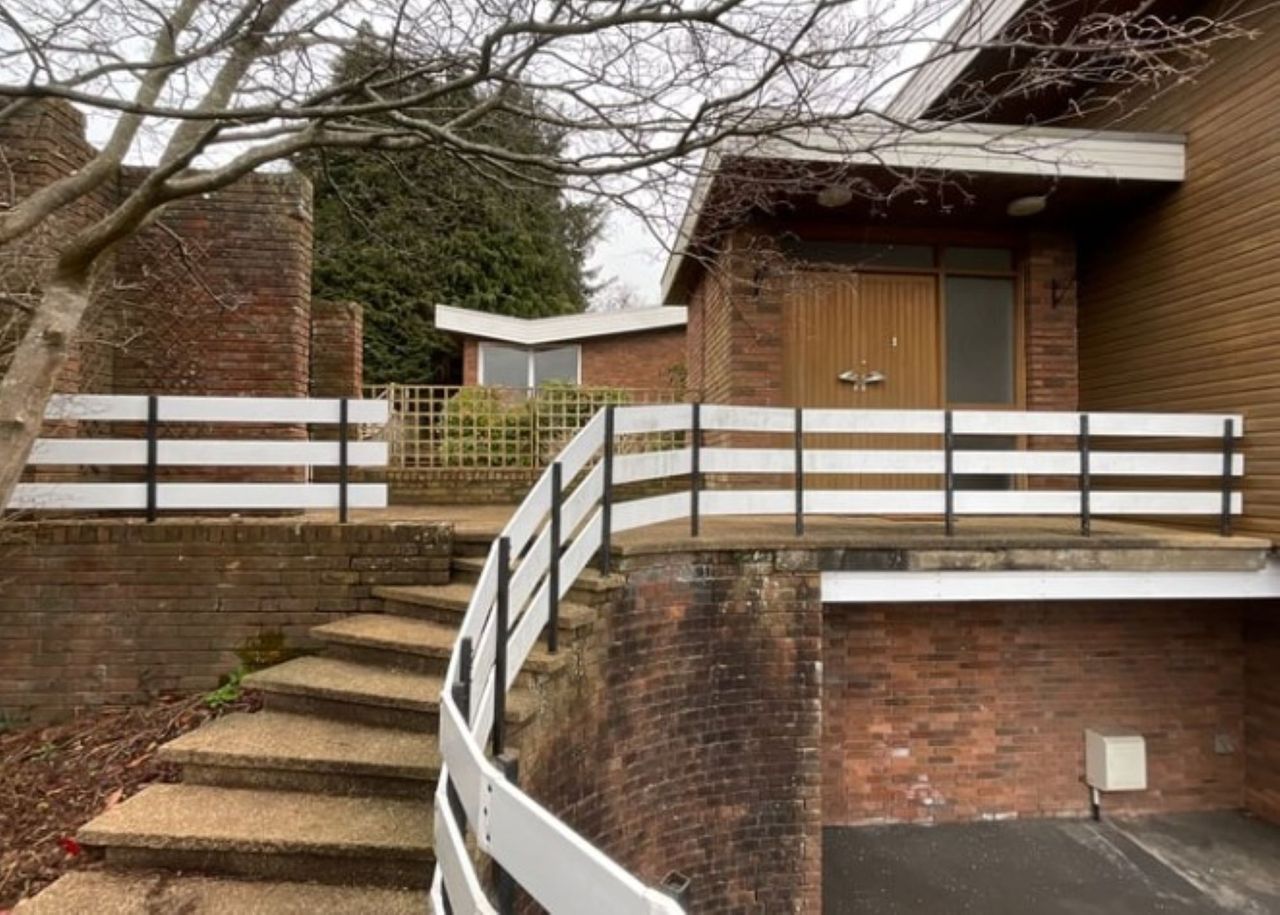 The staircase next to the driveway leads up to the properties entrance