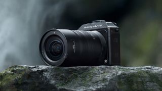 Hasselblad XCD 20-35E lens, mounted to a Hasselblad X2D, sitting on a rocky ledge in front of a waterfall