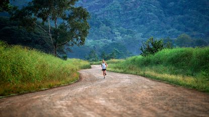 Man running in nature using a Garmin Forerunner watch